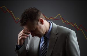 A sad investor looks down with his hands on his forehead. Is the stock market going to crash?