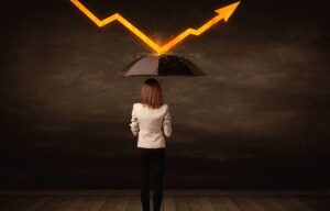 A woman holds up an umbrella to minimize her risk. How does diversification protect investors from risk?