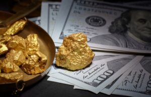 Gold chunks and cash representing how to invest in gold stocks.