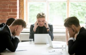 Several investors looking gloomy in their office during a recession.