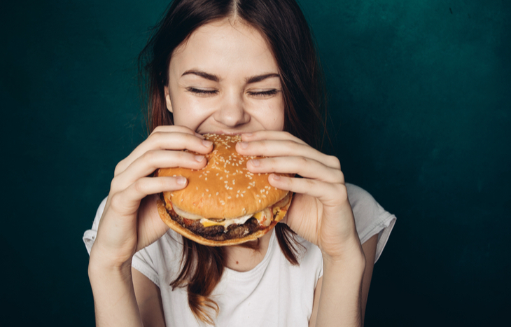 A fast food stocks owner tests out a burger