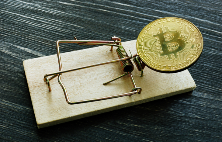Bitcoin in a mousetrap to illustrate crypto scams.